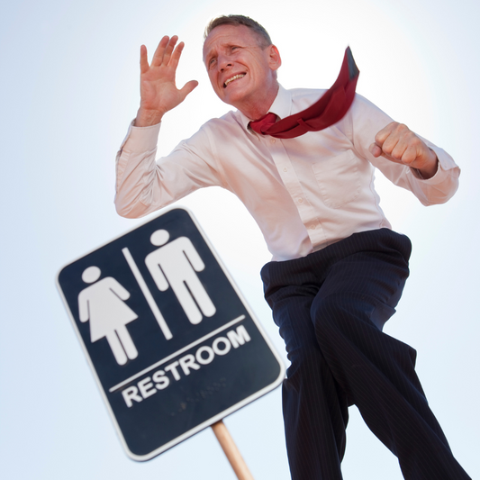 Man running past a restroom sign hoping to get to the bathroom before its to late